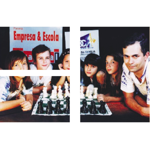 Foto do Sr. José com alunos em uma escola e uma xadrez em sua frente.
